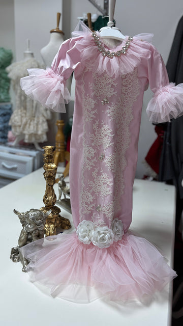 Pink lace dress with floral details on a mannequin against a blurred background