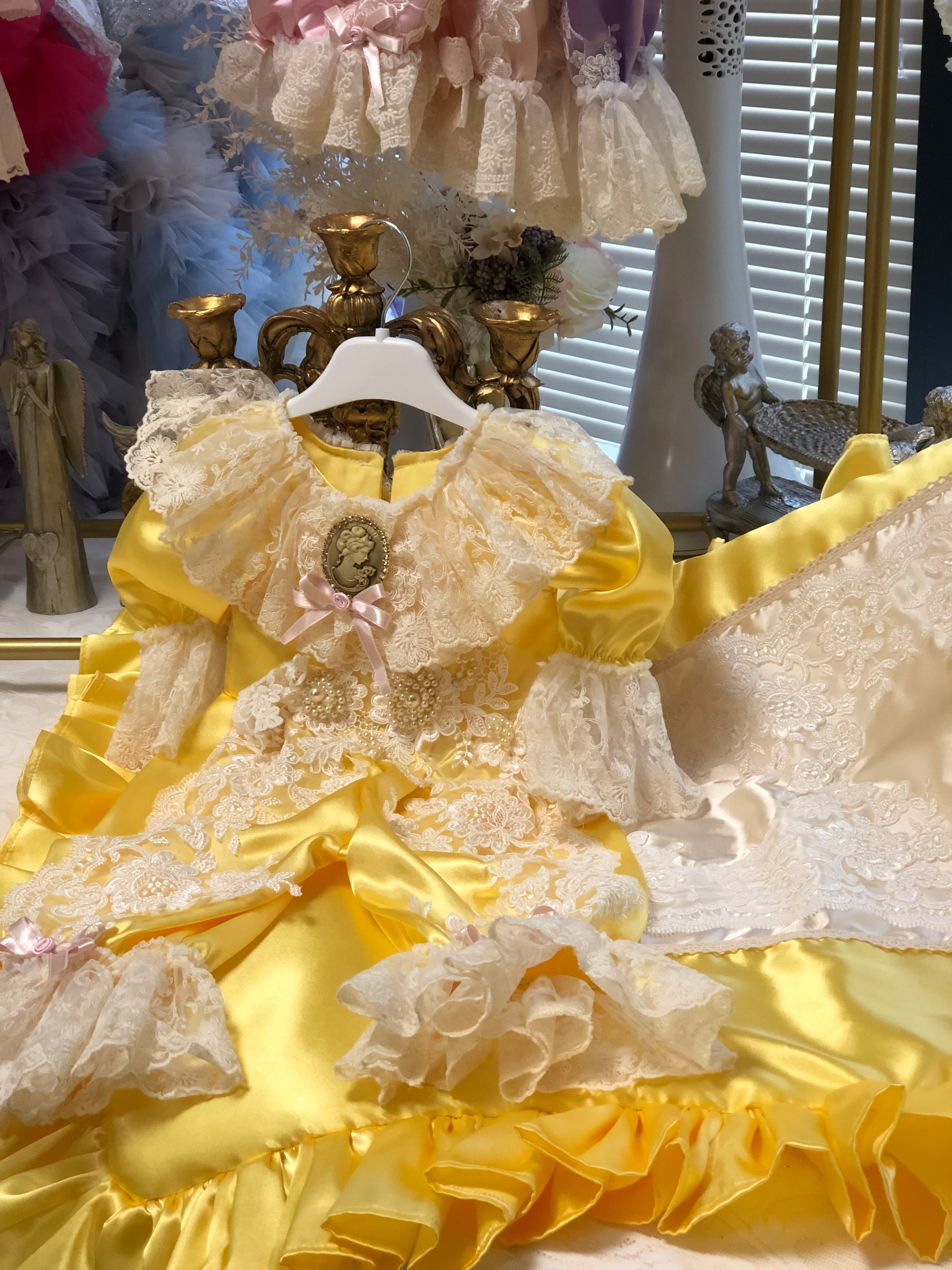 Close-up of a decorative yellow and white fabric with ruffles and lace details.