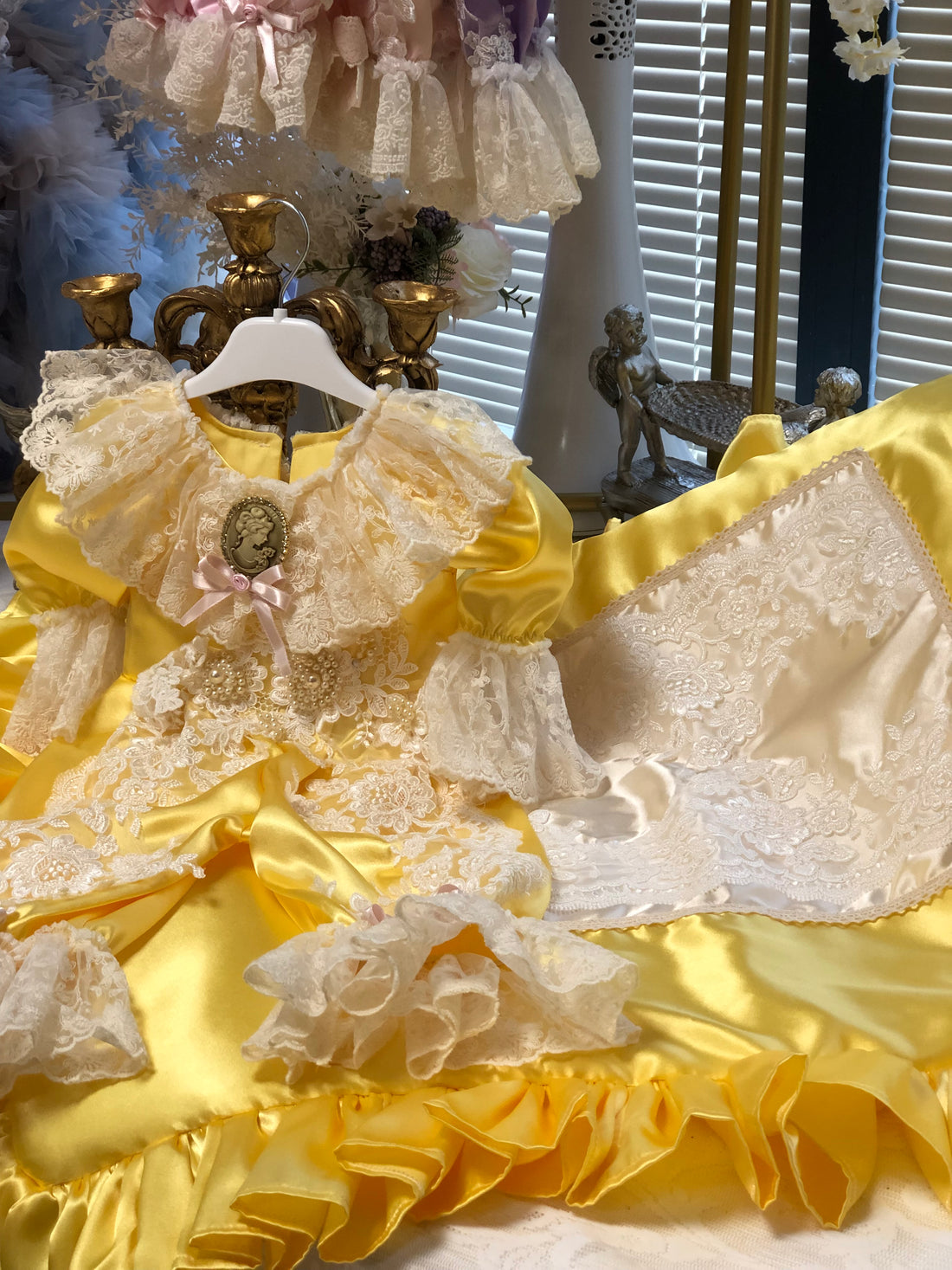 Close-up of a decorative yellow and white fabric with ruffles and lace details.
